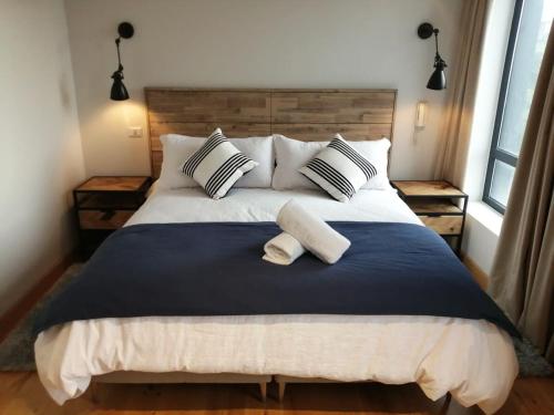 a bedroom with a large bed with two pillows at 6PAX Depto Vista al Lago, 1Parking en Puerto Varas Servicio HOM in Puerto Varas