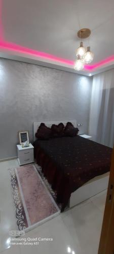 a bedroom with a bed and a pink lighting at Mansbay beach in Aïn Harrouda
