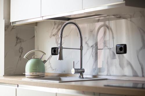 a kitchen sink with a green tea kettle on it at Casa Enea - Luxury House Milano Navigli in Milan