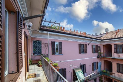 a view of a pink building from a balcony at Casa Enea - Luxury House Milano Navigli in Milan
