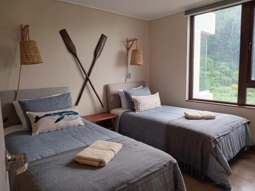 um quarto com 2 camas e uma janela em Espectacular Depto 2D2B Frente al Lago y Parking Servicio HOM em Puerto Varas