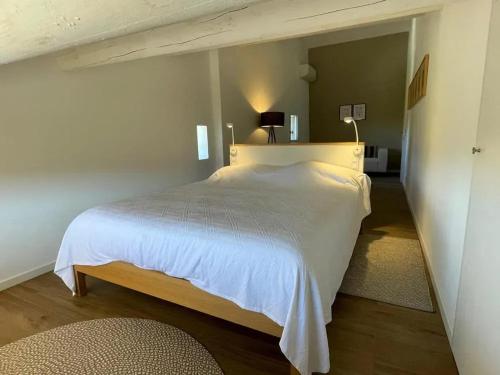 une chambre avec un grand lit blanc dans une pièce dans l'établissement Villa luxueuse à Ménerbes + piscine, à Ménerbes