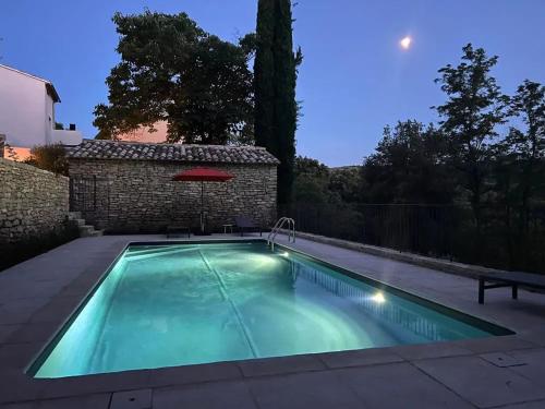 une piscine dans un jardin la nuit dans l'établissement Villa luxueuse à Ménerbes + piscine, à Ménerbes