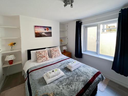 una camera da letto con un letto e due asciugamani di Sleep 2 Cosy Flat With Modern Amenities a Brighton & Hove