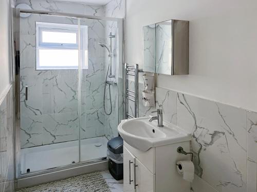 ein weißes Bad mit einem Waschbecken und einer Dusche in der Unterkunft Sleep 2 Cosy Flat With Modern Amenities in Brighton & Hove