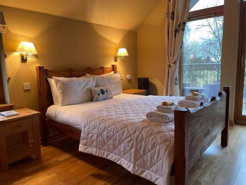 a bedroom with a large bed with towels on it at Lodges at the Mains in Inverness