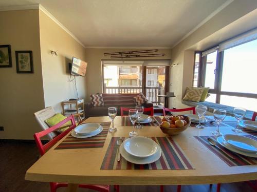 a dining room table with plates and wine glasses at HOM I 6PAX Ski-Out en Valle Nevado Edif El Plomo EP607 in Farellones