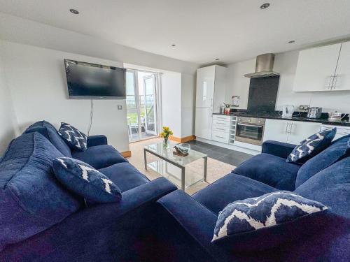 a living room with a blue couch and a table at Waves Guest Suites in Castel