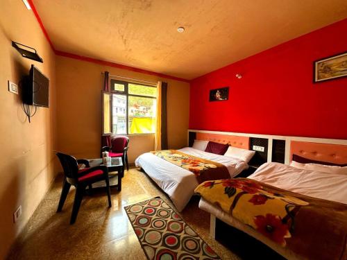 バドリーナートにあるBadrinath Guest Houseの赤い壁のベッドルーム1室(ベッド2台付)