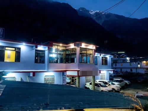 un edificio con coches estacionados en un estacionamiento por la noche en Badrinath Guest House, en Badrīnāth