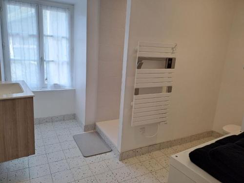 La salle de bains blanche est pourvue d'une baignoire et d'un lavabo. dans l'établissement CASTEL HOME, à Châteaubourg