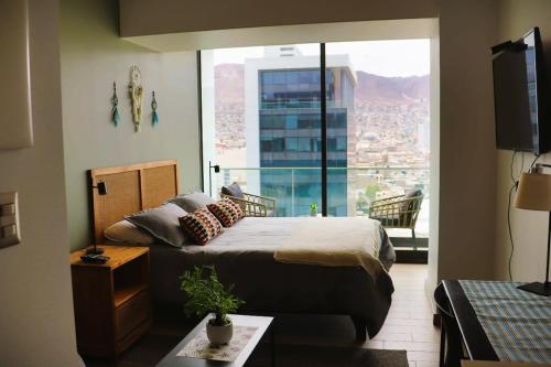 1 dormitorio con cama y ventana grande en Acogedor depto Home estudio ServicioHOM 0516, en Antofagasta
