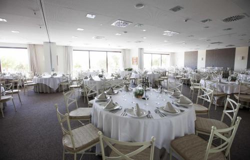 a room full of tables and chairs with white tablecloths at Vincci Valdecañas Golf in El Gordo