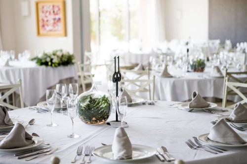 a dining room with tables with white tablecloths and glasses at Vincci Valdecañas Golf in El Gordo