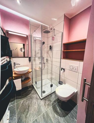 a bathroom with a shower and a toilet and a sink at Café-Hotel Gutshof in Neunkirchen