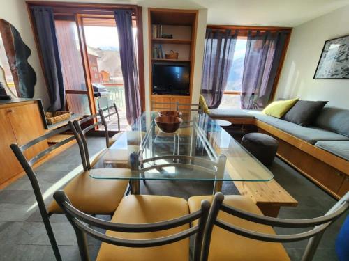 a living room with a glass table and chairs at Edif Mirador del Inca Espectacular Loft En Valle Nevado 10PAX Piscina in Lo Barnechea