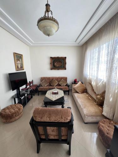 uma sala de estar com um sofá e uma televisão em 16e Étage : Confort & Vue em Casablanca