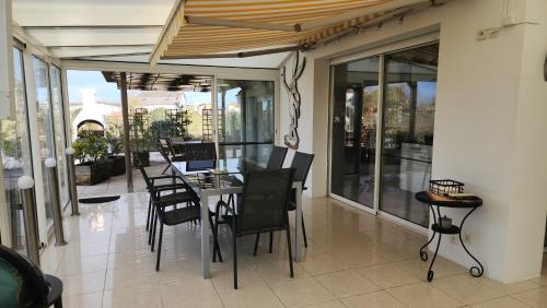 une salle à manger avec une table et des chaises sur un balcon dans l'établissement Villa de vacances avec Piscine, Billard & Pétanque, à Saint-Georges-de-Didonne