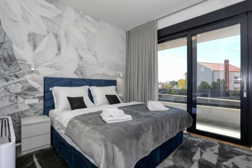 a bedroom with a bed and a large window at Villa Didov San Family Residence with Pool in Zaton