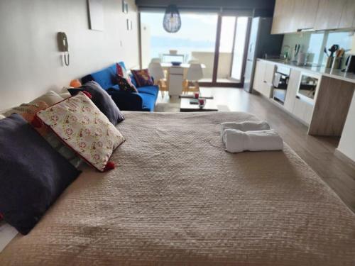 a large bed with two towels on it in a room at HOM I Estudio Nuevo con preciosa Vista y Estacionamiento in Valparaíso