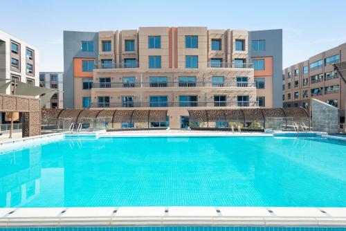 une grande piscine en face d'un bâtiment dans l'établissement Radisson Residences Cairo Heliopolis, au Caire