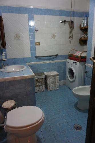 a bathroom with a toilet sink and a washing machine at Casa Girgenti in Vallececa
