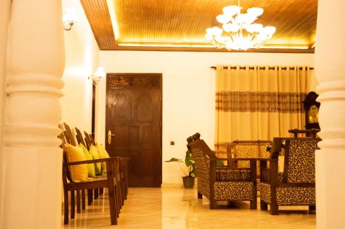 a dining room with chairs and a chandelier at B&B Shenal Villa Kosgoda in Kosgoda