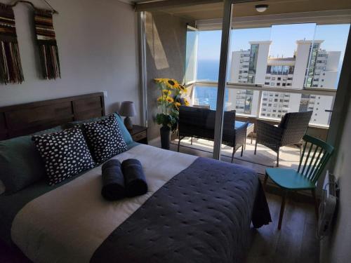 a bedroom with a bed and a view of a city at HOM I Dúplex de Lujo en Concón con Terraza vista al mar 0421 in Concón