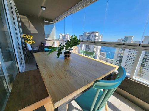 a wooden table with a potted plant on a balcony at HOM I Dúplex de Lujo en Concón con Terraza vista al mar 0421 in Concón