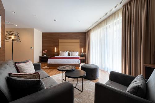 a hotel room with a couch and a bed at Hotel De‘Andros Virpazar in Virpazar