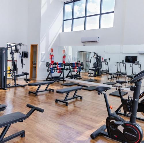 a gym with rows of treadmills and exercise bikes at Inova Flat aconchego no Condominio Cosmopolitan in Palmas