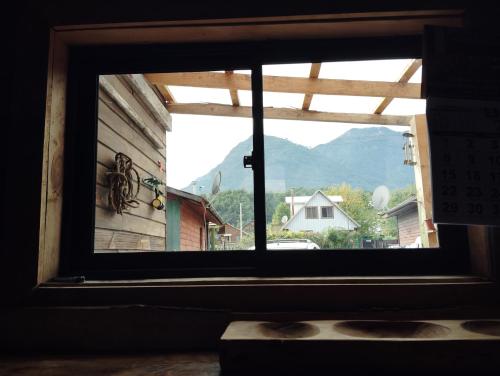 a window in a building with a view of a mountain at hostal Coñaripe in Panguipulli