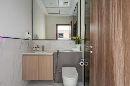 a bathroom with a toilet and a sink and a mirror at Frank Porter - Aria by Grovy in Dubai