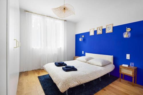een blauwe slaapkamer met een bed met een blauwe muur bij Nouveau - Harmonia in Nantes
