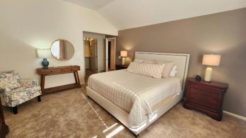 una camera con letto, sedia e specchio di Birchwood Dream a Harbor Springs