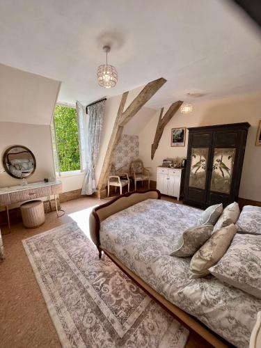 une chambre avec un grand lit et une grande fenêtre dans l'établissement Attic Suite, Maison de Mags & Mags, à Lanouaille