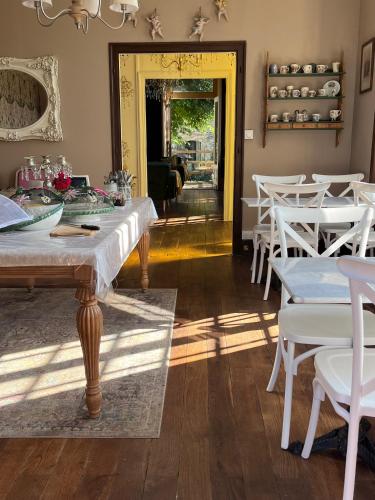 une salle à manger avec des tables blanches et des chaises blanches dans l'établissement Attic Suite, Maison de Mags & Mags, à Lanouaille