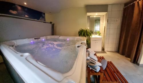 a large bath tub in a bathroom at Gîte Bleuet, petit LOFT 2 à 6 personnes, avec salle de jeux et SPA dans la résidence in Ventron