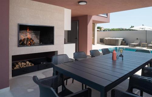comedor con mesa y chimenea en Gorgeous Home In Vrsi With Wifi, en Vrsi