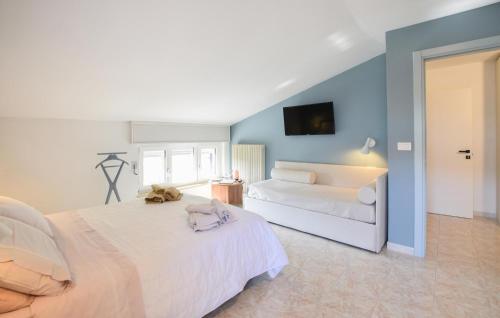 a bedroom with a large white bed and a couch at Pet Friendly Apartment in Borgofranco dʼIvrea