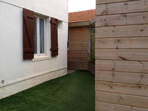 a backyard with a wooden fence and green grass at Loft Biarritz proximité Mer et Golf in Biarritz