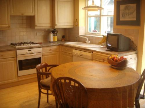 a kitchen with a table with a bowl of fruit on it at spacious in Croxley Green