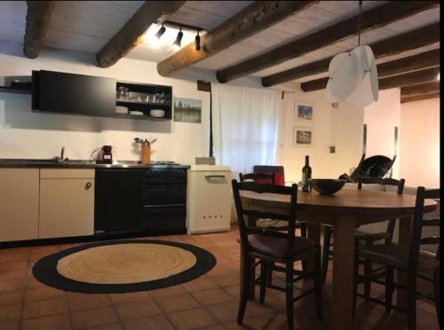 eine Küche und ein Esszimmer mit einem Tisch und Stühlen in der Unterkunft Verzasca Lodge Matilde in Frasco