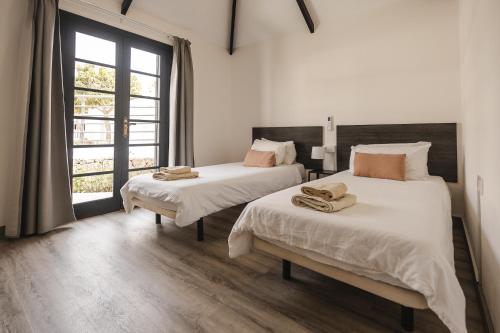 a bedroom with two beds and a window at Los Cardones Boutique Village in Playa de las Americas