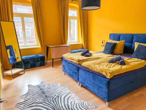 a bedroom with a blue bed and yellow walls at *4 Personen, 2 Zi, zentrumsnah* in Pirna