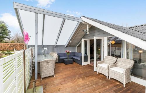 a screened porch with wicker chairs and a table at 3 Bedroom Lovely Home In Ørsted in Ørsted