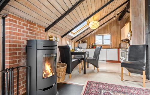 a living room with a fireplace and a dining room at 3 Bedroom Lovely Home In Ørsted in Ørsted