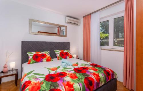 Un dormitorio con una cama con flores rojas. en Cozy Apartment In Vantacici With House Sea View en Vantačići