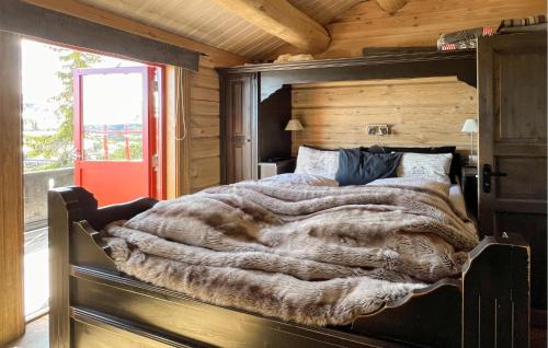 a bedroom with a large bed with a wooden wall at Cozy Home In Trysil With Wifi in Trysil
