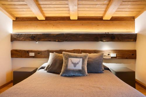 a bedroom with a large bed with wooden ceilings at Locanda Ca Bianca - Family Suite in Roccabruna
